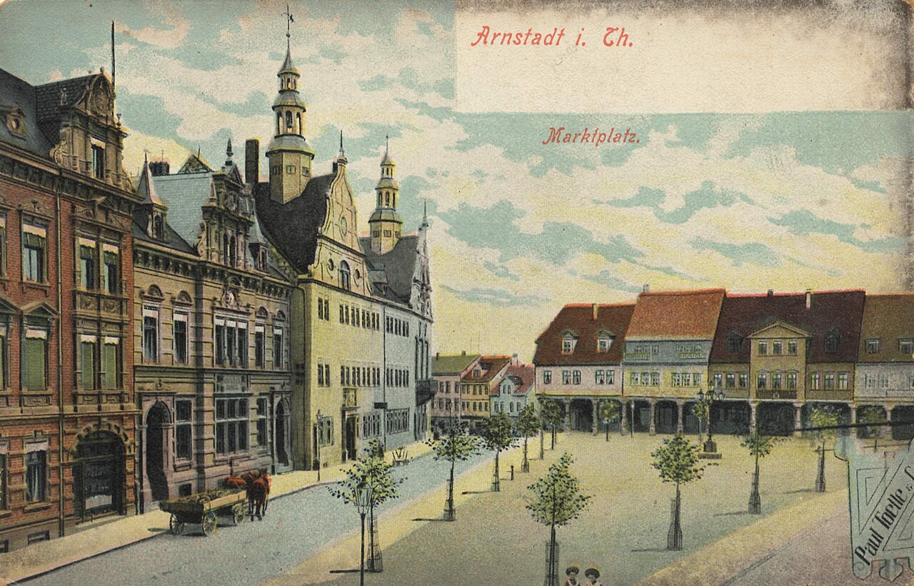Kolorierte Ansicht des Arnstädter Marktplatzes mit Rathaus, Menschen und einem Wagen.