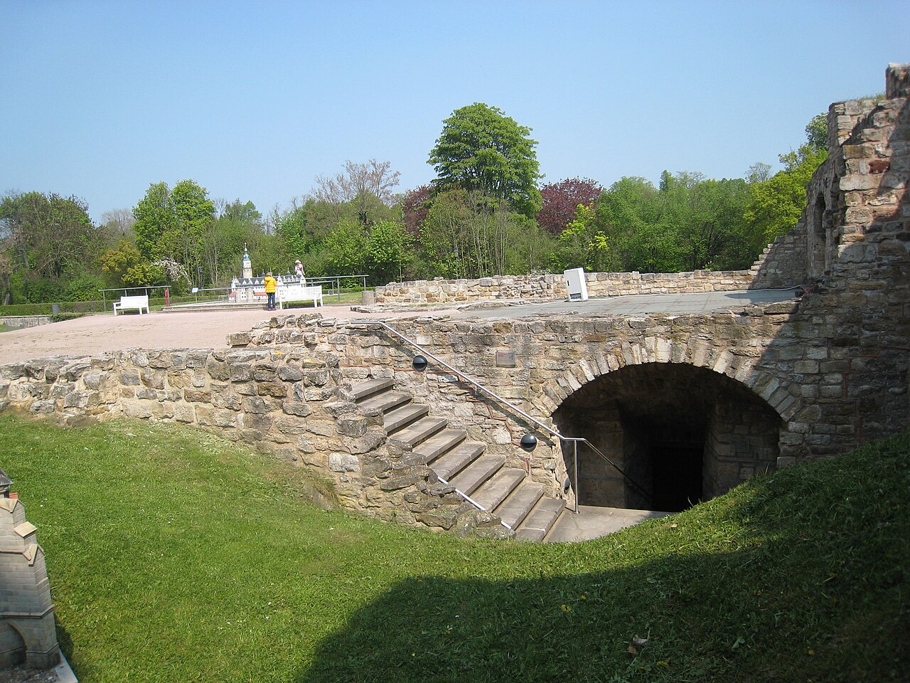 Treppe und Gewölbeöffnung in einer begrünten Schlossruine.